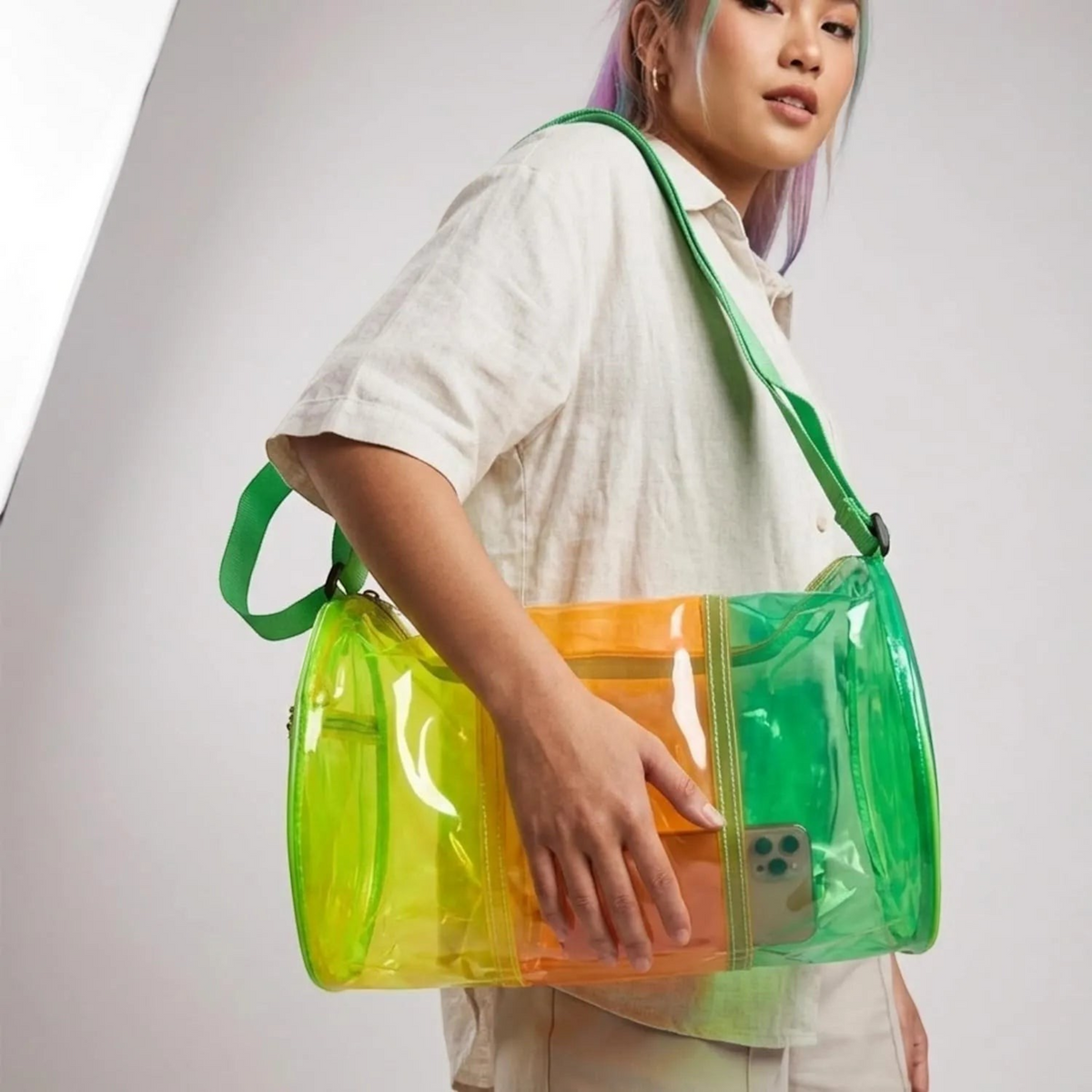 TipTop Retail neon transparent PVC jelly duffle bag with green shoulder strap worn by a model