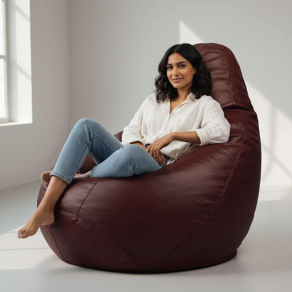 A woman sitting comfortably in a TipTop Retail choco brown teardrop bean bag cover made of soft-touch fabric.