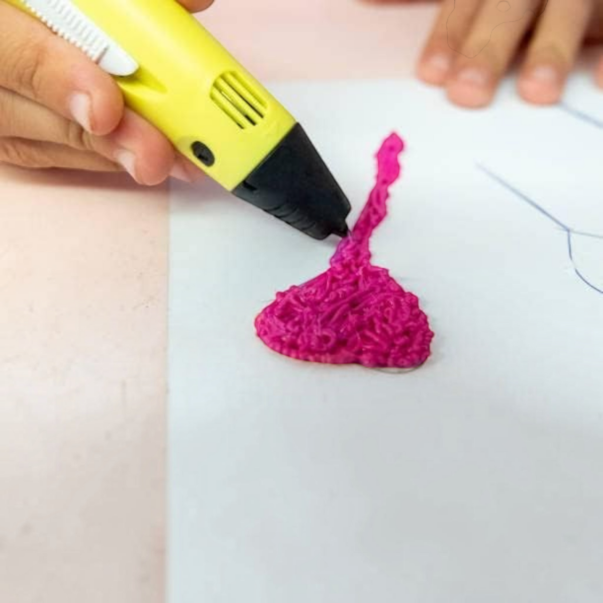 TipTop Retail yellow 3D printing pen drawing a pink heart shape on white paper with PLA filament